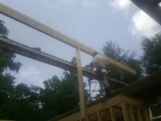 Carpenter setting a ridge beam over a new addition frame — Ice Dam Removal by Roofing Brothers in West Islip