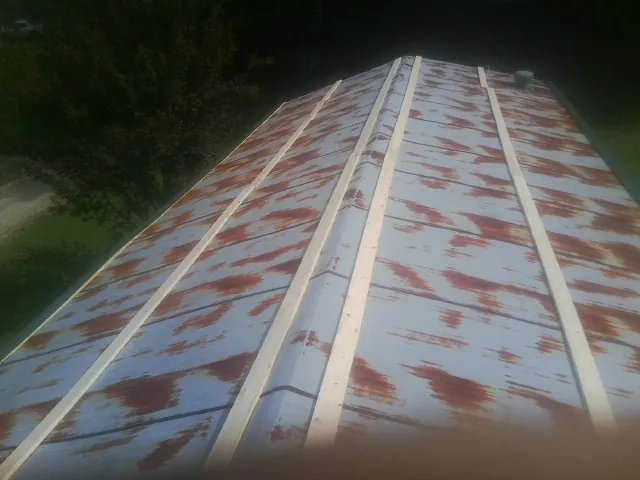 Rusted metal roof panels with new wood purlins before replacement — Storm Damage Roof Repair in West Islip by Roofing Brothers