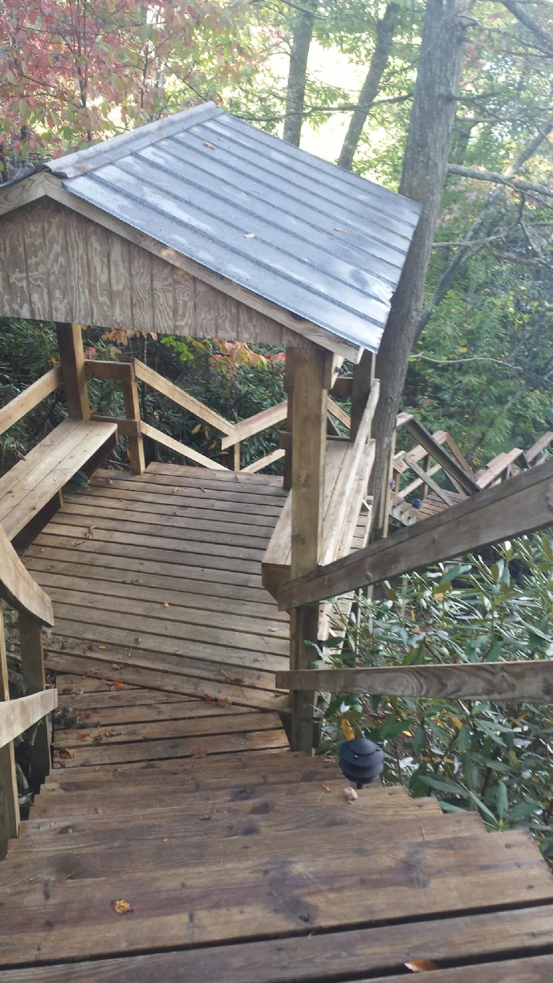 Metal roofed shelter over wooden steps on a wooded walkway — Skylight Repair & Installation work by our crew in West Islip