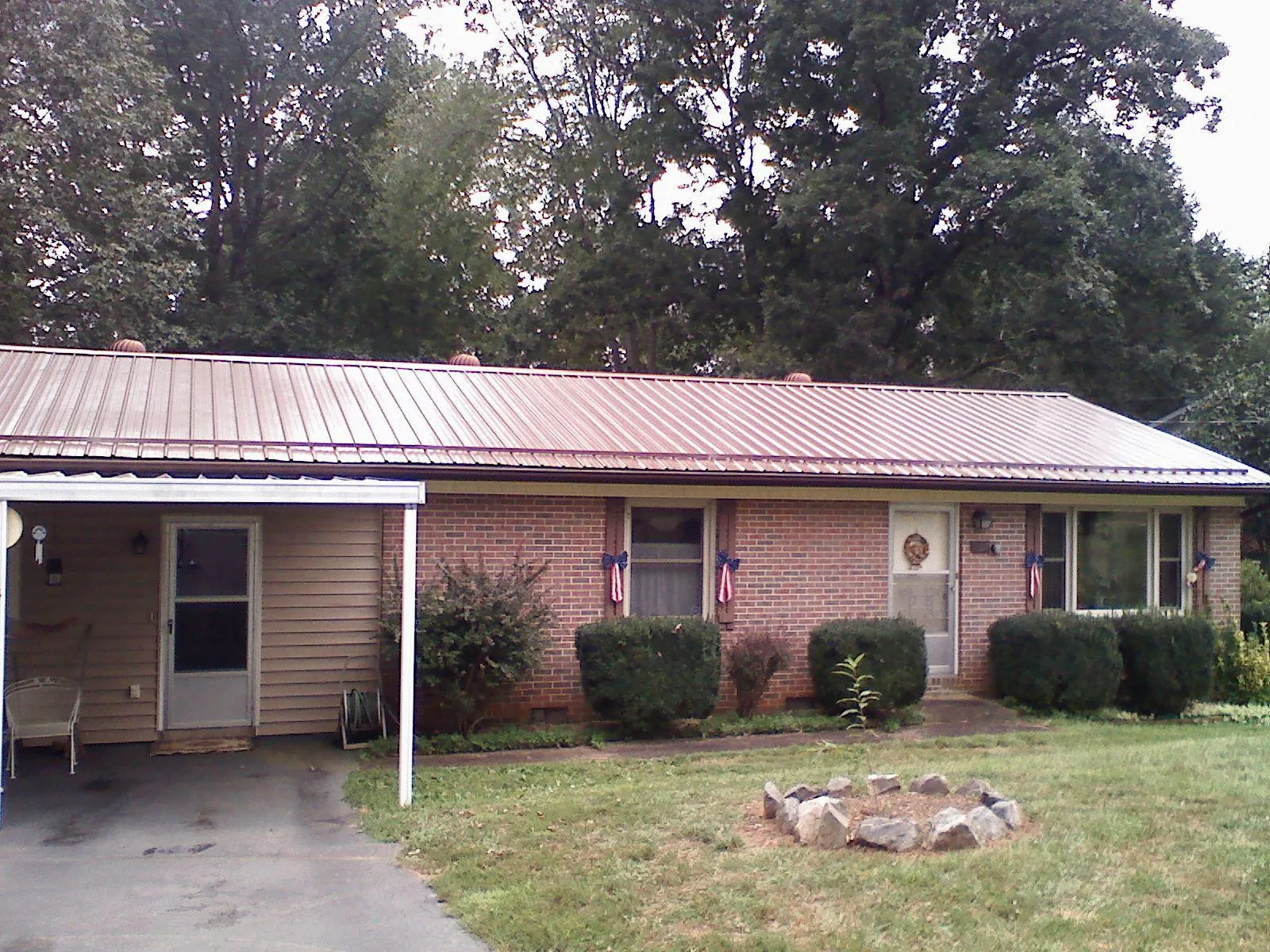 Bronze metal roof and carport on a brick ranch home — Roof Repair work by our crew in West Islip